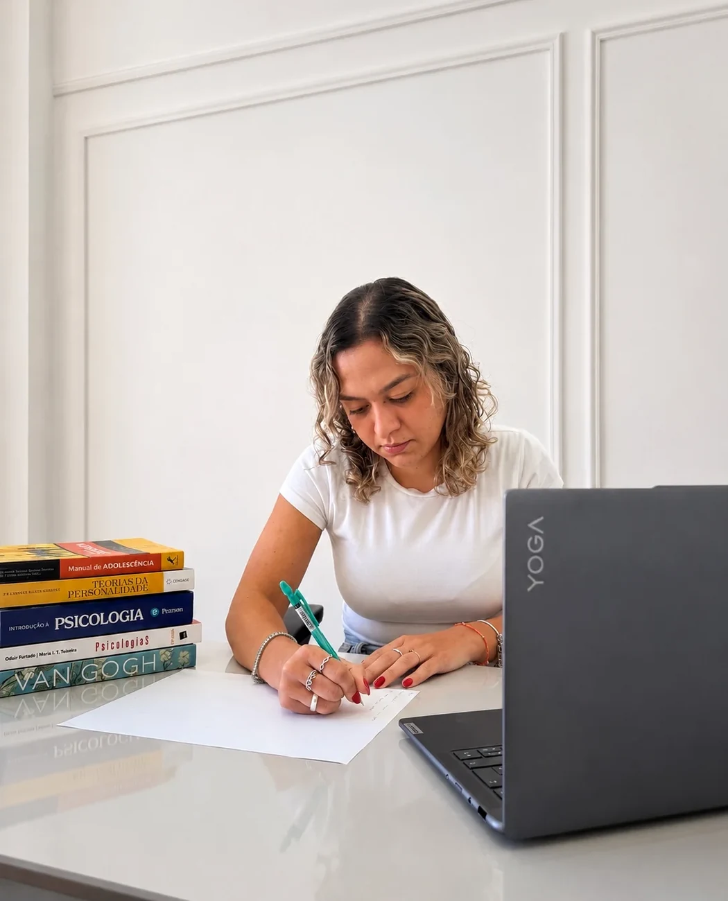 Larissa Benites escrevendo em sua mesa de trabalho